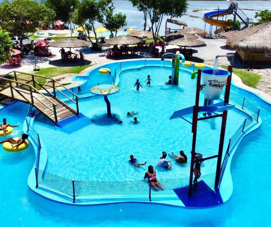 Área Kids do Paraíso dos Tambaquis em Estância, Sergipe, com piscina de águas cristalinas, playground aquático, balde gigante e crianças se divertindo com segurança